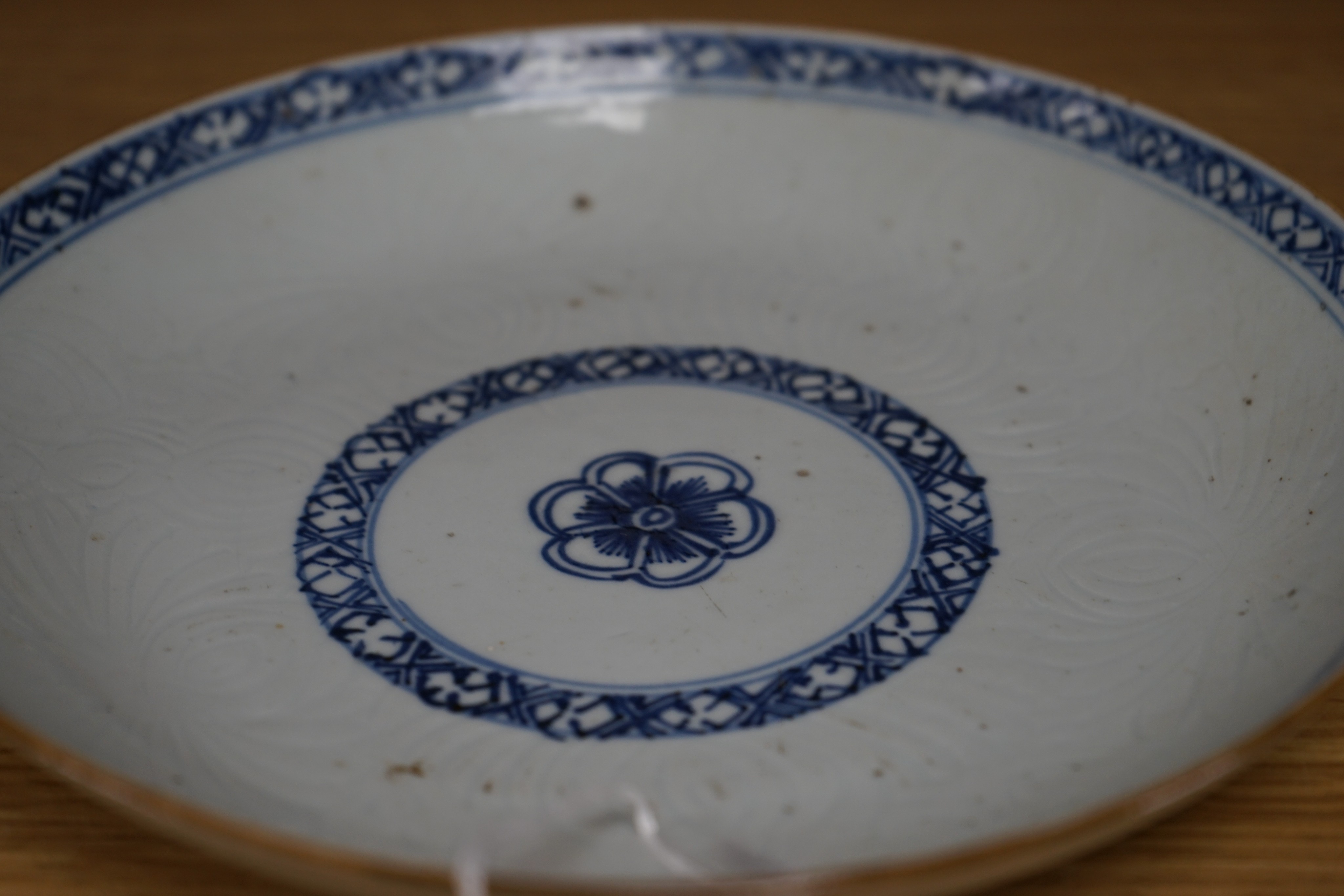 An 18th century Chinese shallow circular blue and white dish with incised decoration, Dia 22cm